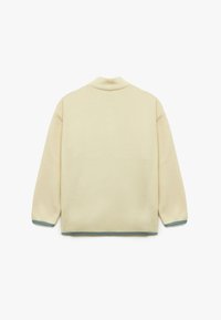 Cremfarbener Fleece-Jacke mit hohem Kragen, überschnittenen Schultern und hellblauer Borte an den Bündchen und dem Saum. Keine sichtbaren Verschlüsse.