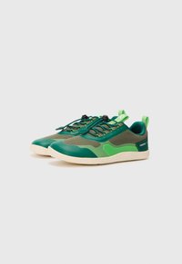 Zapatillas deportivas verdes con malla y tejido suave, con punta redondeada, cordones elásticos y una suela texturizada para agarre y flexibilidad.