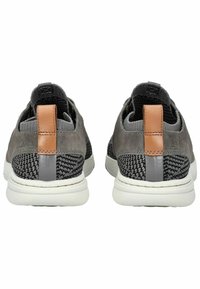 Graue Sportschuhe mit einer strukturierten schwarzen Stoffferse, braunem Lederakzent und weißer Außensohle. Verfügt über eine Zuglasche an der Rückseite.
