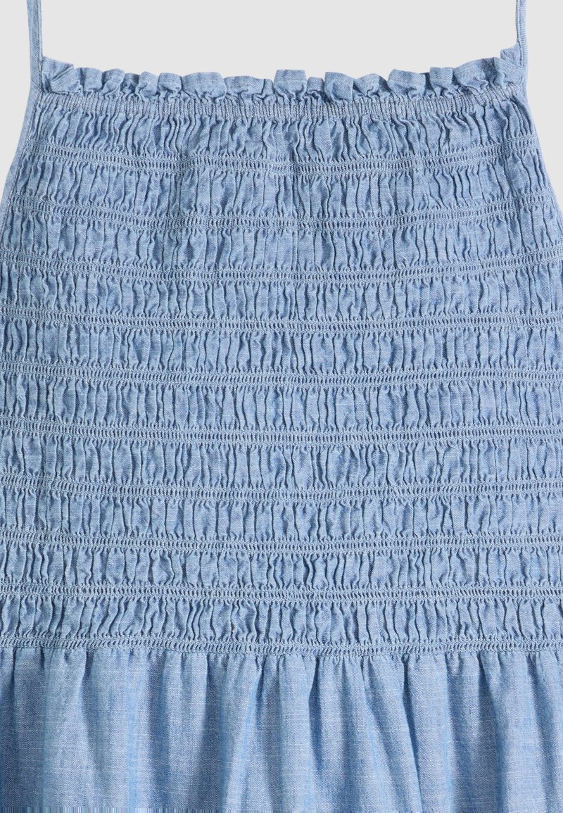 Robe légère bleu clair sans manches avec corsage smocké et froncé, fines bretelles, en tissu léger.