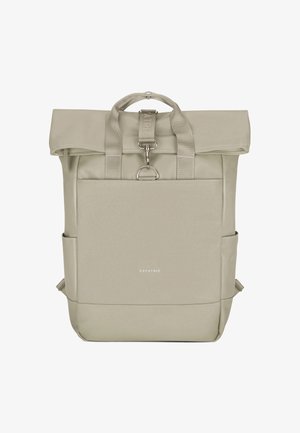 Sac à dos beige à rabat enroulable avec poche avant, doubles poignées, poches latérales et fermeture par boucle métallique, marqué « EXPATRIÉ » sur le devant.