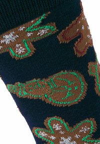 Tissu en maille marine avec des bonshommes en pain d'épice marron décorés de détails cousus blancs, verts et rouges en motif répété.