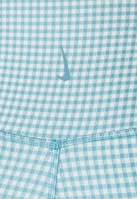 Tkanina w niebiesko-białą kratkę, z subtelnym logo. Tekstura jest gładka, z widocznymi detalami ściegów.