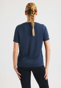 T-shirt corto blu navy in un tessuto morbido e liscio. Presenta una vestibilità comoda e un collo rotondo, con un branding sottile sulla manica.
