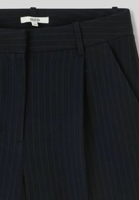 Pantalons à rayures bleu marine foncé avec passants de ceinture, poches latérales et étiquette de taille blanche 36 marque BZB à l'intérieur de la taille.