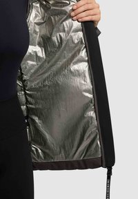 Schwarze Jacke mit einem metallisch silbernen Innenfutter und dunklen grauen Akzenten. Verfügt über einen Reißverschluss und einen Kordelzug am Saum. Weiche Stofftextur.