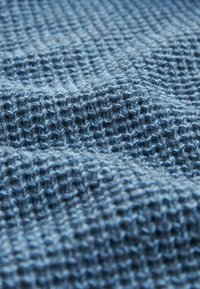 Gestructureerde brei stof in verschillende tinten blauw, met een losse weving en een zachte, fuzzige oppervlakte. Ideaal voor kleding of textiel.