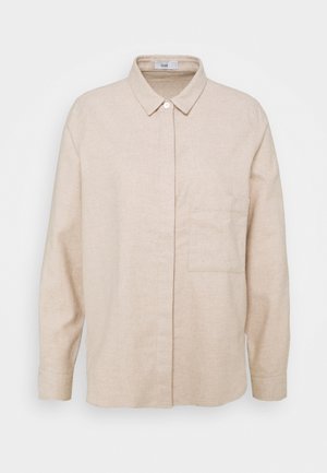 Beige langærmet skjorte med klassisk krave, en enkelt brystlomme, skjult knaplukning og knapmanchetter på hvid baggrund.
