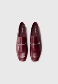 Et par burgundy læder loafers med sølv kæde detalje og firkantet tå, Calvin Klein branding indeni.