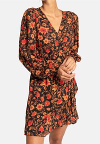 Robe noire à motifs floraux avec de longues manches bouffantes, ornée de fleurs rouges et oranges, décolleté en V et ourlet à volants.