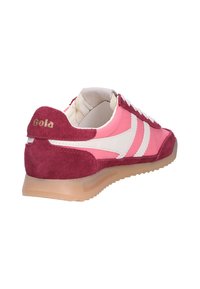 Baskets en suède rose et bordeaux avec des bandes blanches, intérieur rembourré et semelle en gomme, inclinées pour montrer les détails arrière et latéraux.