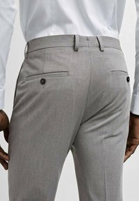 Sive prilagođene hlače s glatkom teksturom, s stražnjim džepovima s crnim dugmadima i slim fit dizajnom.