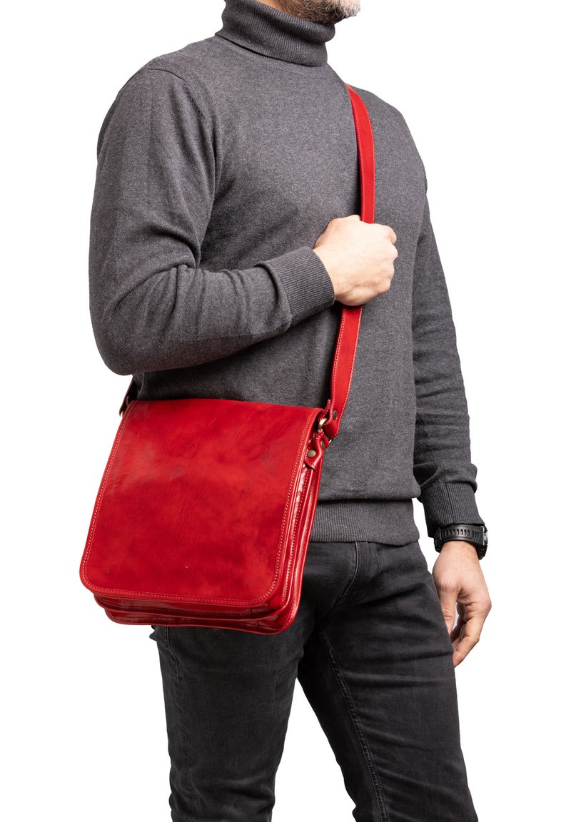 Borsa a tracolla in pelle rossa con una texture liscia e raffinata, tracolla regolabile e forma rettangolare, indossata a tracolla.