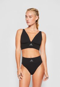 Črn dvodelni bikini z globokim izrezom na braletu s širokimi naramnicami in visokim pasom. Adidasov logo v sivi barvi na obeh delih.