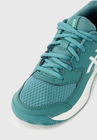 Παπούτσι αθλητικού τύπου σε τιρκουάζ χρώμα με επάνω μέρος από δίχτυ και συνθετικό υλικό, στρογγυλεμένες μύτες, επίπεδα κορδόνια, επένδυση στη γλώσσα και υφή στη λαστιχένια σόλα με πράσινες λεπτομέρειες.