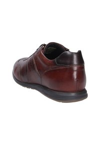 Brązowy skórzany but o gładkiej teksturze, okrągłym nosku i subtelnych detalach w szyciu. Wyposażony w czarną gumową podeszwę zapewniającą przyczepność.