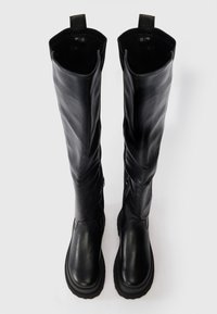 Botas de couro pretas até ao joelho com uma textura suave, leve brilho e fechos laterais em zíper, com solas de borracha duráveis.