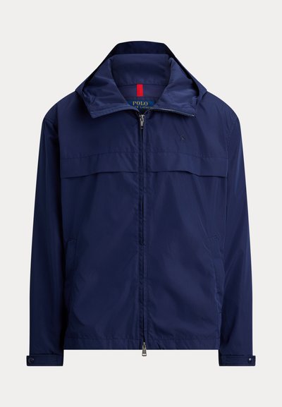 Veste légère bleu marine zippée avec col montant, poignets boutonnés et poches latérales, logo Polo Ralph Lauren sur la poitrine.