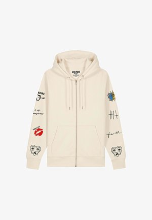Hanorac crem cu fermoar, buzunare frontale, glugă cu șnur și desene grafice care includ un soare, buze, o inimă plângând și text scris de mână pe ambele mâneci.