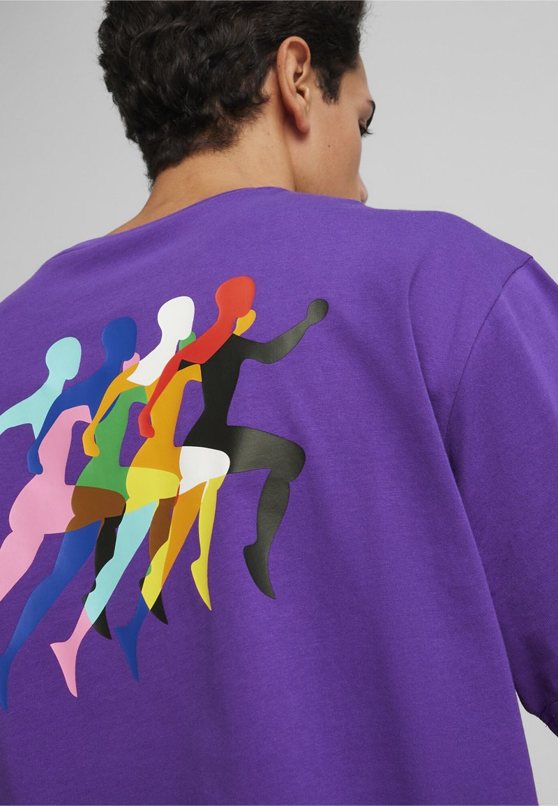 Fialová bavlněná mikina s multicolor grafikou stylizovaných běžců na zadní straně. Hladká textura a uvolněný střih.