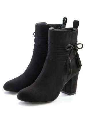 Schwarze Stiefeletten aus weichem Wildleder mit gerafften Details, gebundenen Akzenten und klobigen Absätzen. Glatte Textur, spitze Zehenform, stilvolle Quasten.