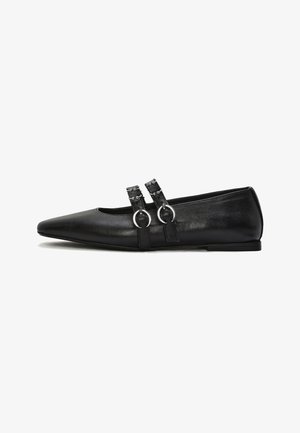 Zapato plano de cuero negro con punta, con dos correas decorativas que presentan hebillas de aro plateadas y pequeños remaches.