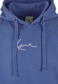 Felpa in cotone blu con cappuccio regolabile e logo ricamato bianco. Il tessuto ha una texture liscia e una vestibilità rilassata.