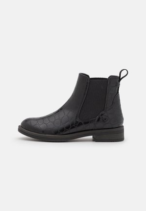 Black ankle boot featuring a textured, embossed pattern, elastic side panels, pull tab, and a low stacked heel. Smooth leather finish.