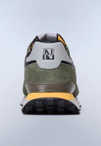 Zielone zamszowe i czarne skórzane sneakersy z żółtymi akcentami, fakturowana czarna podeszwa oraz szary uchwyt na pięcie z czarno-białym logo.