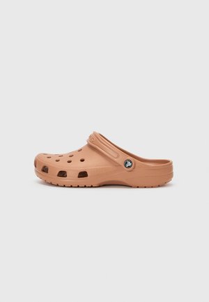Čevlji v stilu crocs v svetlo rjavi barvi, izdelani iz lahkega materiala. Imajo več ventilacijskih lukenj in trak za peto za varno prileganje.