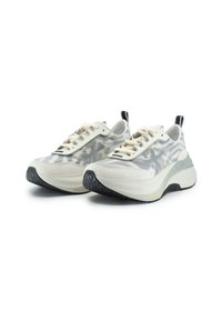 Weiße und graue Sneakers mit einem Tarnmuster, ausgestattet mit einer dicken Sohle, einem Obermaterial aus Stoff und kontrastierenden schwarzen Akzenten an Ferse und Zunge.