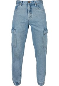 Světle modré cargo kalhoty vyrobené z denimu, s bočními kapsami, se zúženými nohavicemi a elastickými manžetami na kotnících.