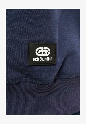 Tumesinine sweatshirth, millel on sooneline tekstuur. Esiküljel on must plaastrilogo valge ninasarviku siluetiga ja tekst "eckō unlt'd." paremas alumises nurgas.