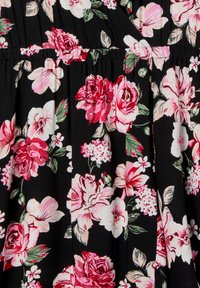 Tessuto nero con un motivo floreale che presenta rose rosa e bianche, ibisco e verde; texture morbida con dettagli arricciati in tutto il tessuto.