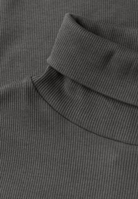 Maglione a collo alto grigio scuro con una texture a coste, caratterizzato da un collo alto e una finitura liscia, che evidenzia l'elasticità del tessuto.