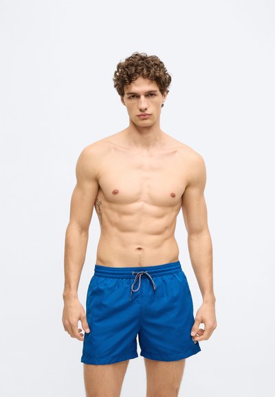 Siniset uimashortsit, joissa on joustava vyötärönauha ja kiristysnyöri. Sileä, kevyt kangas, rento istuvuus ja polven yläpuolelle ulottuva pituus.