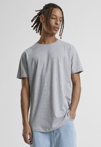Tricou gri cu mânecă scurtă, fabricat din bumbac. Design cu guler rotund și croi lejer. Stil minimalist, cu o textură moale și fără modele vizibile.