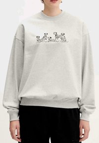 Sudadera gris con mangas largas y puños acanalados. Presenta un diseño ilustrado de perros en negro en la parte delantera. Tela suave y casual.