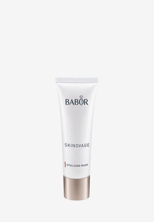 Tube blanche avec un socle doré métallique, étiquetée "BABOR SKINOVAGE MASQUE VITALISANT." Présente une texture lisse et un design minimaliste.