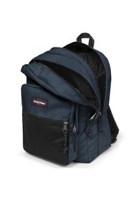 Mochila Eastpak en tela azul marino con un bolsillo de malla negra texturizada. Cuenta con un compartimento principal con cremallera, tirantes ajustables y un asa en la parte superior.