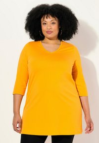 Oranges V-Ausschnitt-Tunikaoberteil mit Dreiviertel�ärmeln, gefertigt aus glattem Stoff, mit geradem Saum und entspannter Passform.