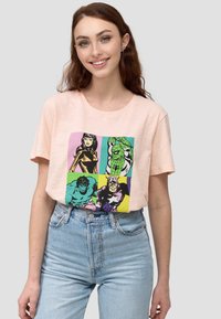 Vaaleanpunainen puuvillapaita, jossa on värikäs sarjakuvaprintti supersankareista. Löysä malli, lyhyet hihat ja pyöreä kaula-aukko.