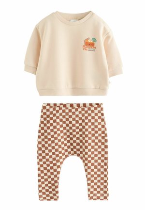 Cremefarbenes Langarm-Kleinkindshirt mit Kürbiskuchen-Grafik und braun-beigen karierten Hosen mit elastischem Bund.