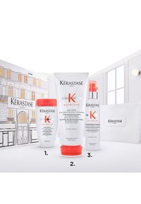 Il set di cura dei capelli Kérastase Nutritive include uno shampoo, un balsamo e un trattamento senza risciacquo. Le bottiglie presentano design bianchi e arancioni con testo chiaro.