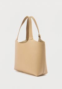 Μπεζ δερμάτινη τσάντα tote με λεία υφή, στρογγυλεμένη κορυφή και μακριά, δεμένα χερούλια. Διαθέτει μινιμαλιστικό σχεδιασμό και ανοιχτή δομή.
