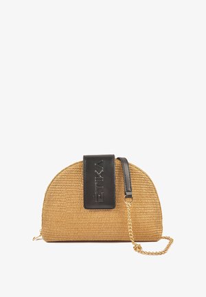 Bolso de paja tejido en color marrón con forma curva, tapa de cuero negro, logo grabado y correa de cadena dorada.