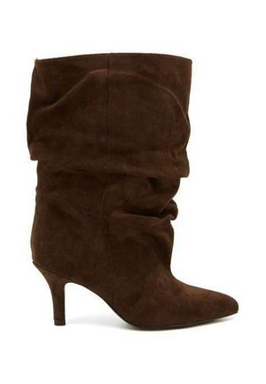 Botte en daim marron mi-mollet avec bout pointu et talon fin type kitten sur fond blanc.