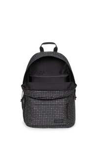 Mochila negra con patrón de cuadrícula blanca, cierre de cremallera, bolsillo frontal y asa superior. El interior está forrado con tela negra sólida y compartimentos.