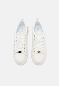 Sneakers bianchi con lacci, dotati di un esterno in pelle liscia, occhielli in tono oro e un logo sulla linguetta. Suole interne imbottite.