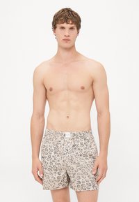 Leopárd mintás boxer nadrág bézs és barna anyagban. Derékpánttal és gombos záródással rendelkezik. Puha, könnyű anyag.